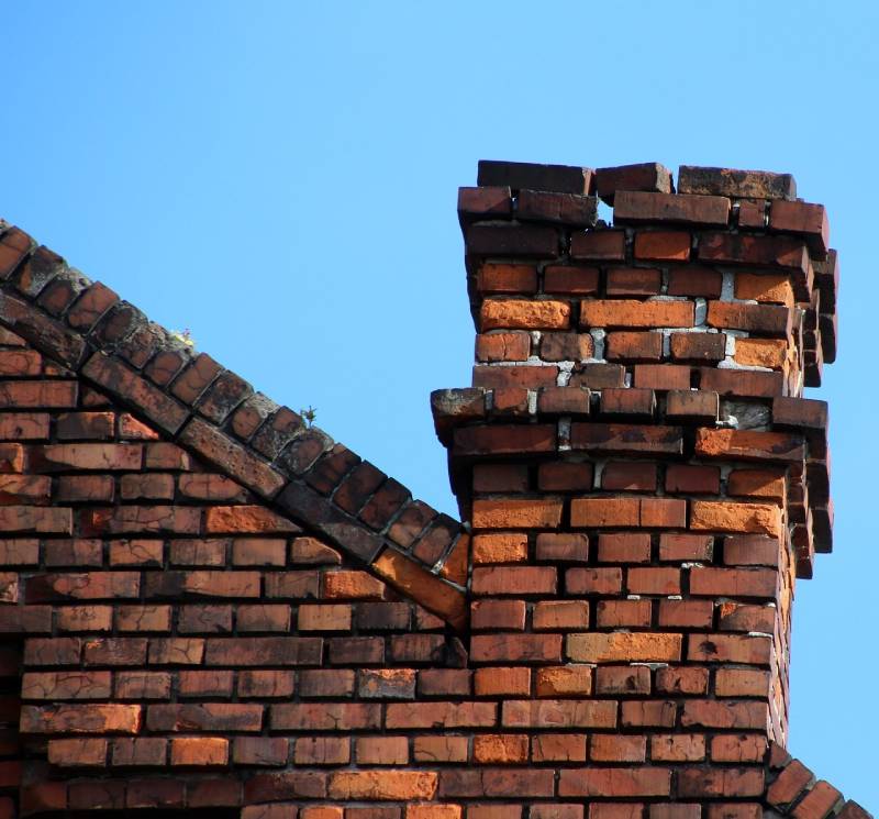 Damaged chimney on an Long Grove home showing cracks and missing mortar